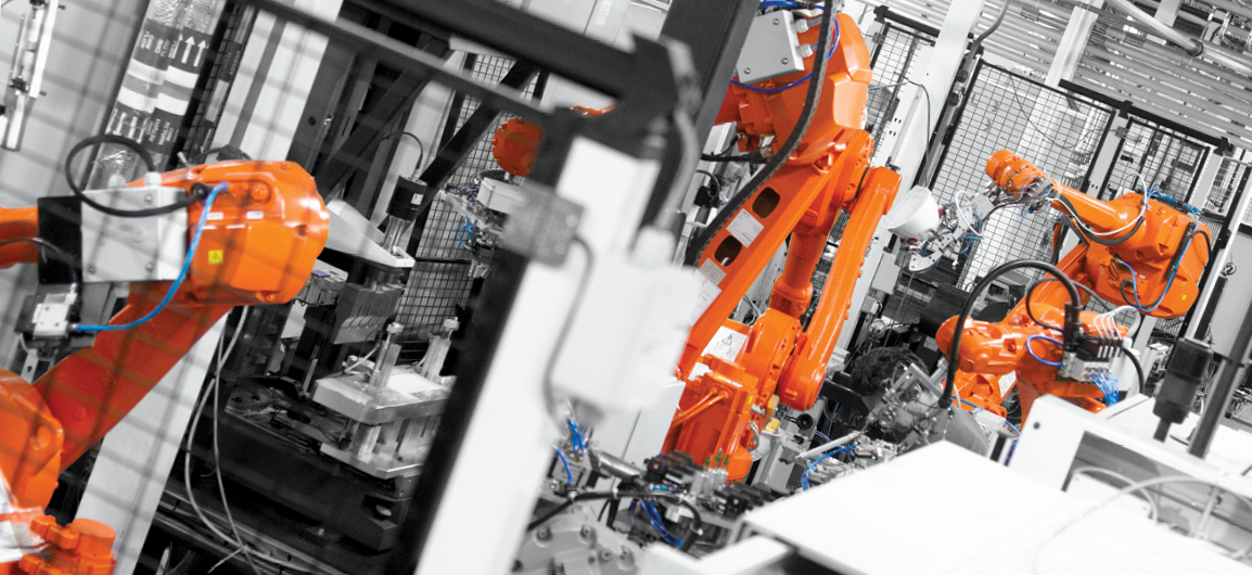 Orange robotic arms in factory